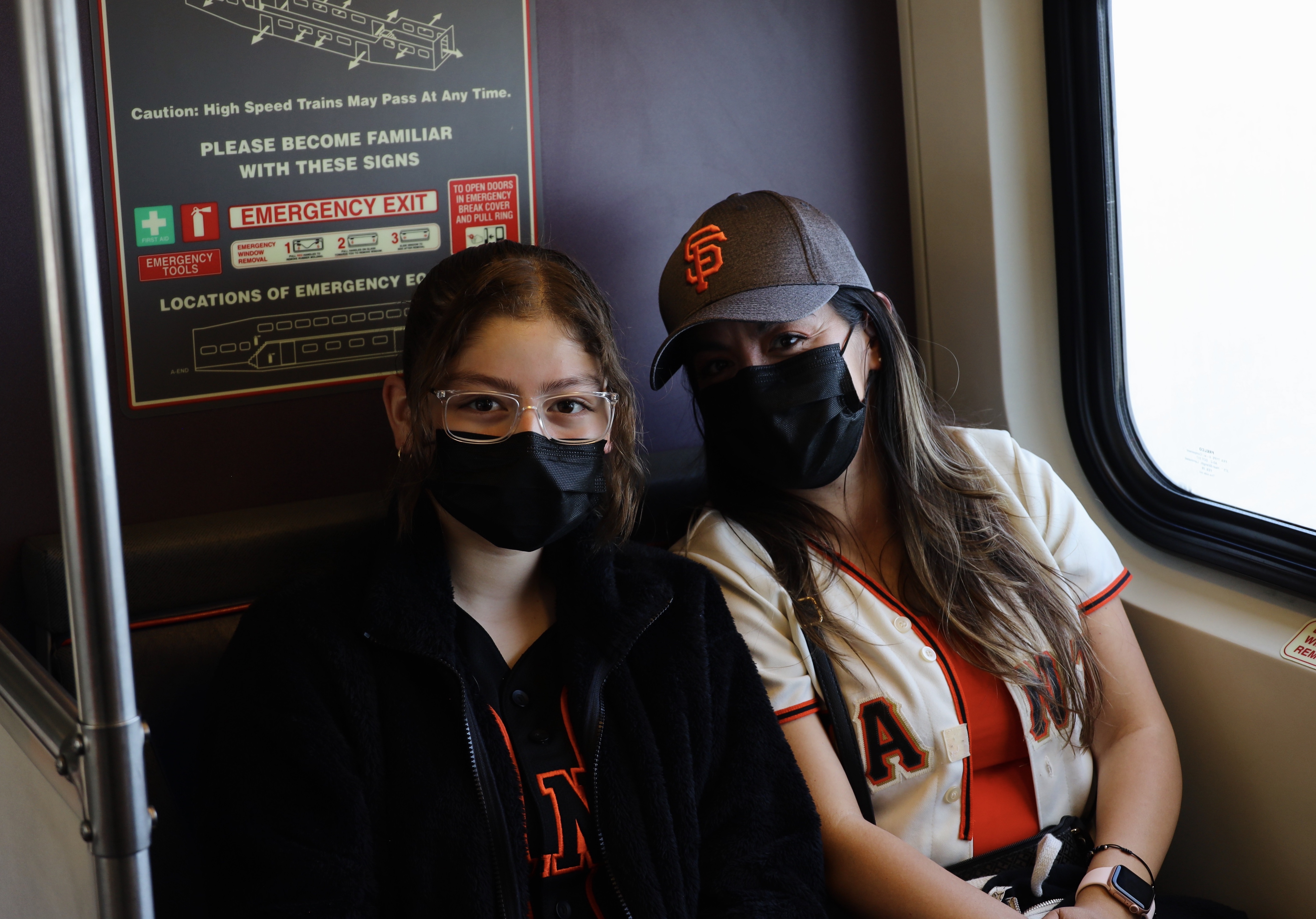 Giants fans on the train wearing masks