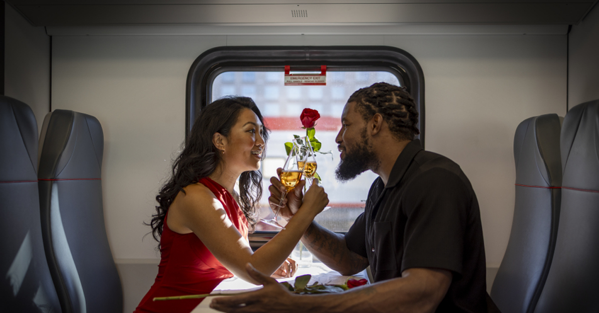 Couple clinking glasses in Caltrain cabin