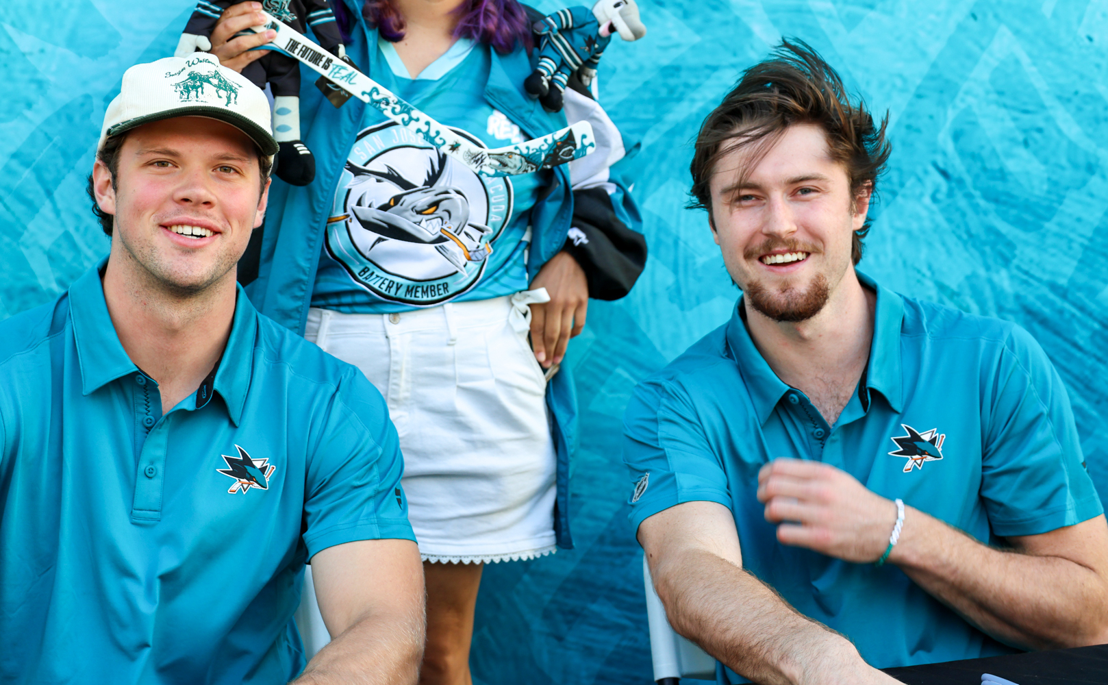 A Caltrain rider poses with San Jose Sharks ack Ostapchuk and Patrick Giles