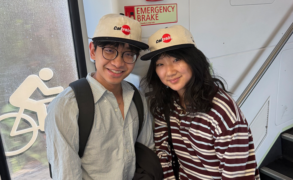 Two people posing with Caltrain Corduroy Hats