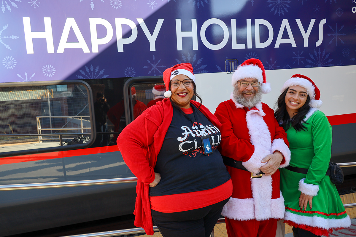 Santa with Elves standing by Holiday Train