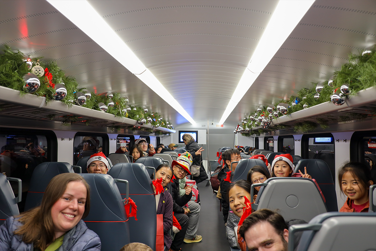 Group poses in decorated Holiday Train
