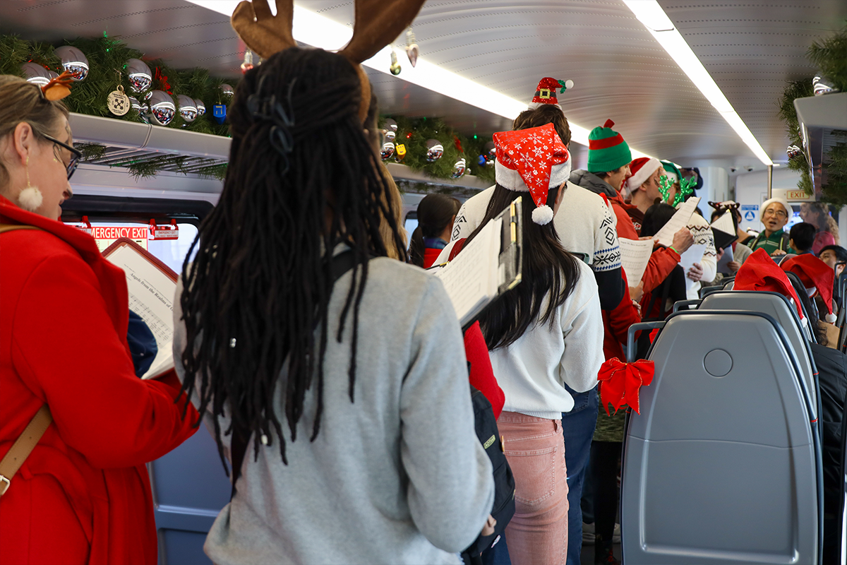 Festive group singing carols aboard Holiday Train