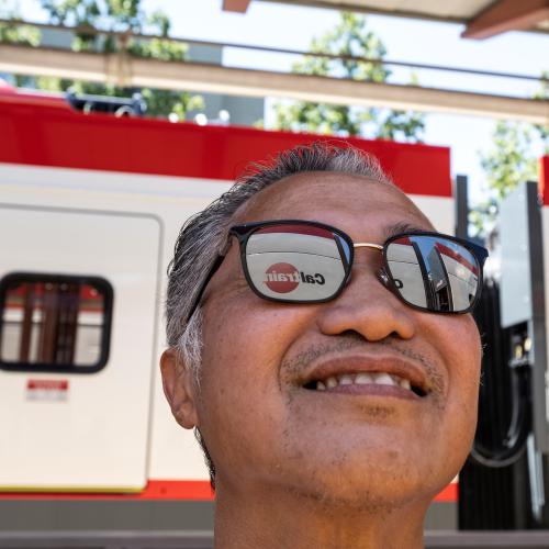 Excited man wearing sunglasses gazes admiringly at the new electric trains