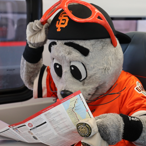 Lou Seal looking at map on a Caltrain EMU