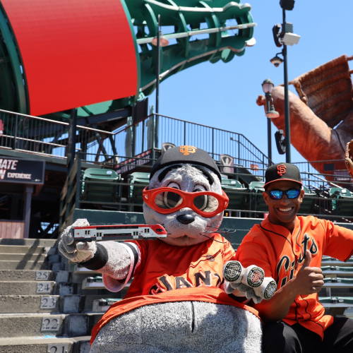 Lou Seal and person posing in bleachers at Oracle Park