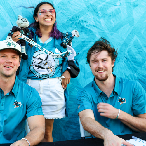 A Caltrain rider poses with San Jose Sharks ack Ostapchuk and Patrick Giles