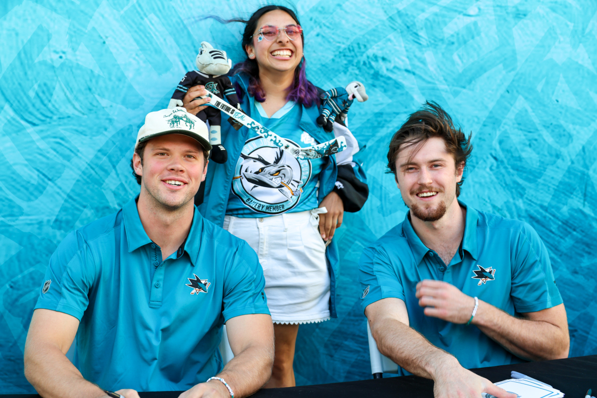 A Caltrain rider poses with San Jose Sharks ack Ostapchuk and Patrick Giles